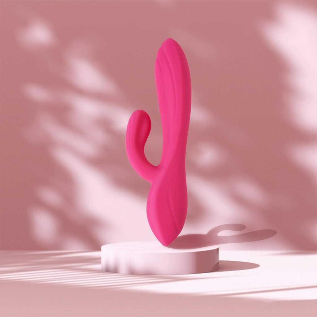 Stylish pink rabbit vibrator displayed on a platform against a soft background for product photography.